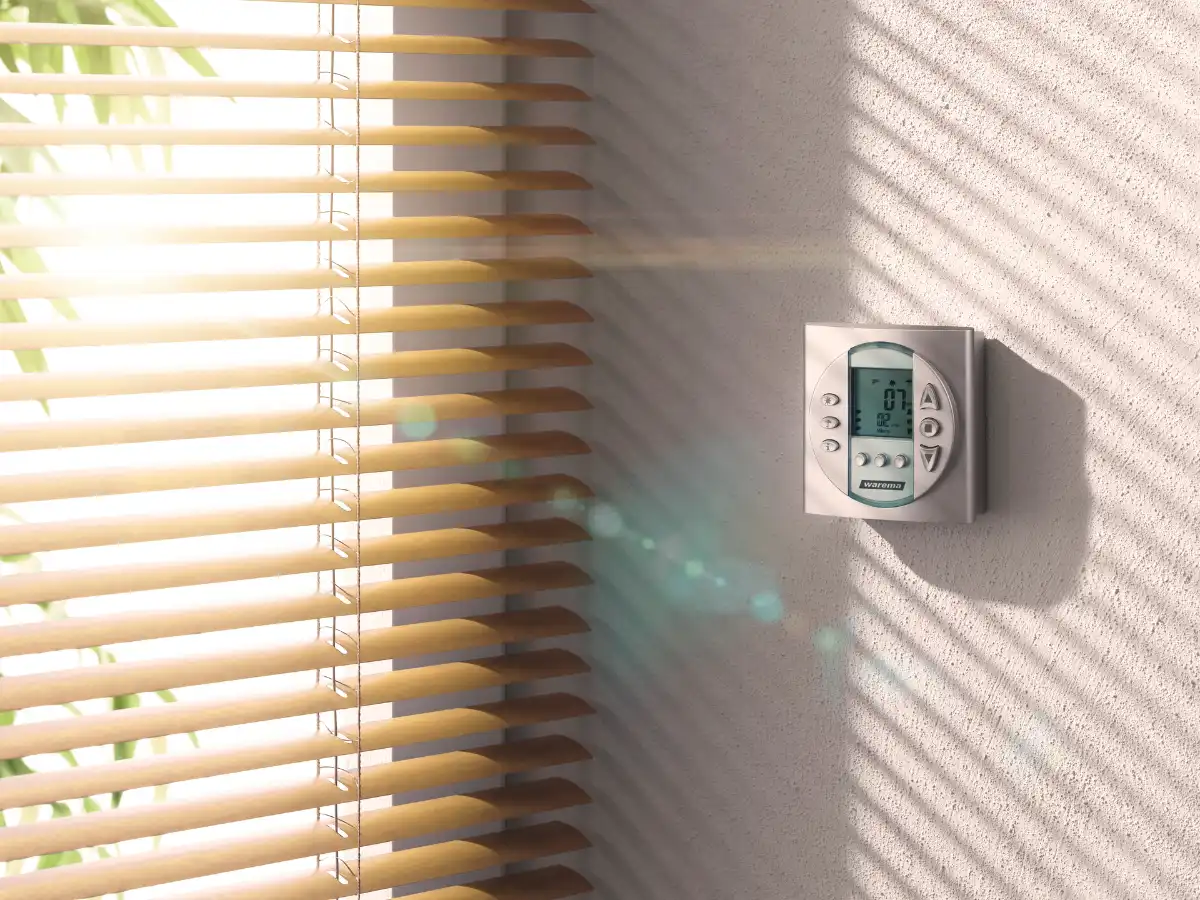 Smart Home Steuerung für Innenjalousie Digitales Thermostat an einer Wand neben Innenjalousien