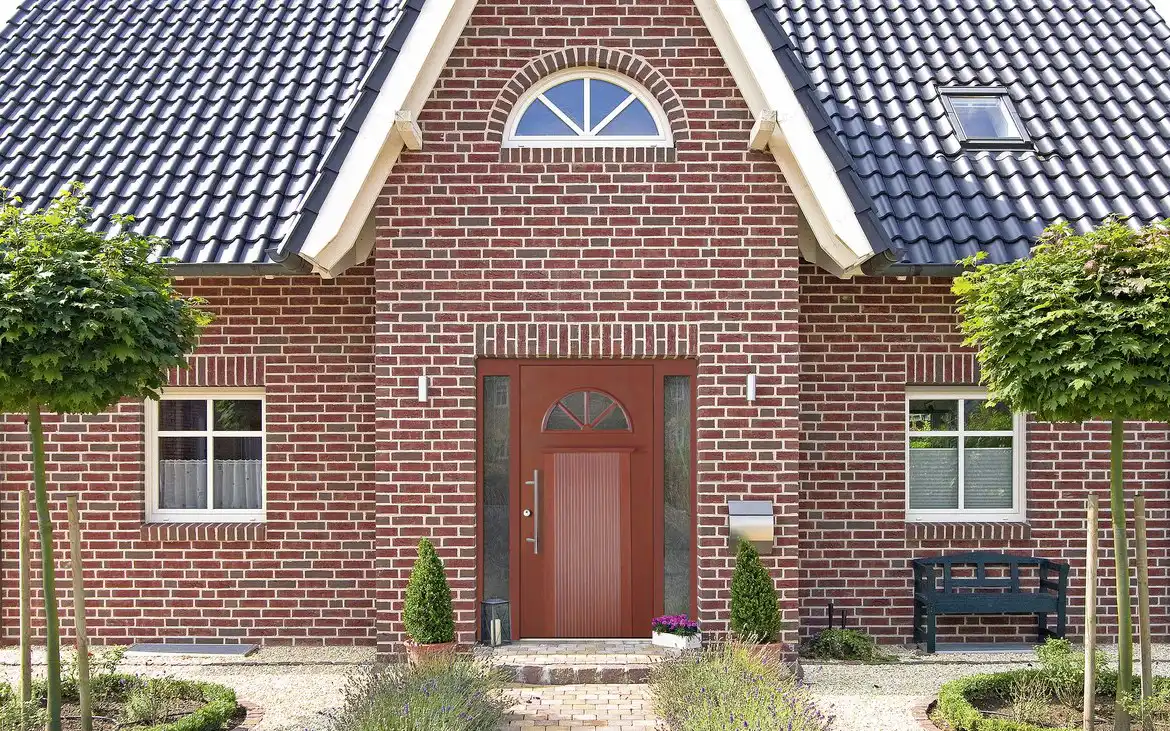 Holzhaustür von Aldra mit gläsernen Inlays an modernem Backsteinhaus in norddeutschem Stil