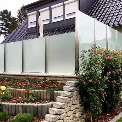Wohnhaus-mit-Garten-der-rundum-geschuetzt-ist-dank-eines-Glas-Sichtschutzes