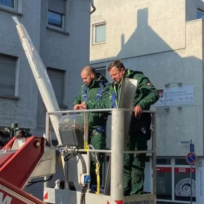 image11 zwei-Maenner-in-gruener-Arbeitskleidung-stehen-in-einem-Krahn